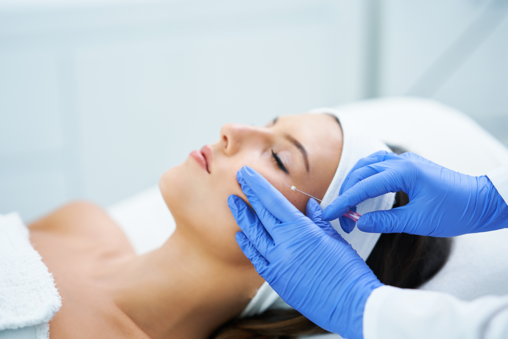 Medical professional performing PDO threads treatment on a woman.