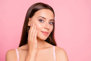 Woman with glowing skin touching her cheek after a PRP vampire facial.