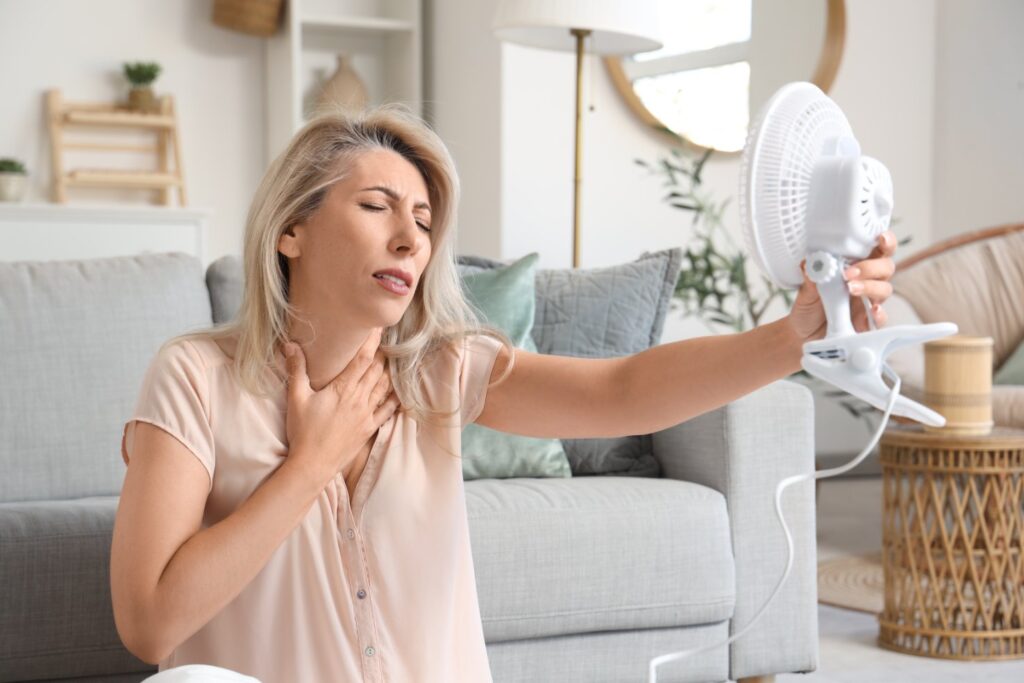 Woman experiencing hot flashes needing hormone replacement therapy.